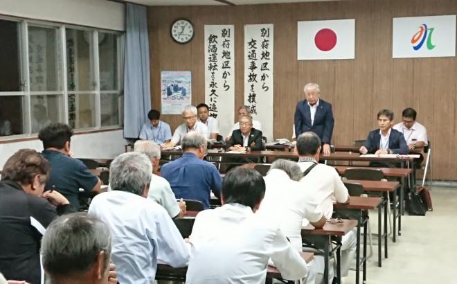 公民館の会議室内で長机の席に座った参加者と関係者が向かい合って座り、奥の中央の席の市長が席を立ち、話をしている様子の写真