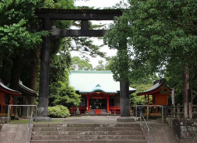 参道へと続く階段から鳥居や大クスや手水舎、黒く大きな鳥居の奥には朱色の社殿が見える、飯倉神社の写真