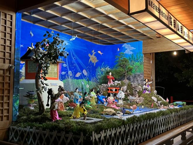 海中を表現した舞台上で、浦島太郎や海の中の竜宮城、乙姫やたくさんの魚たちが舞を踊る様子のからくり人形の写真