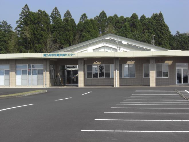 建物前には広々とした駐輪場が整備され、三角屋根で平屋づくりの南九州市知覧保健センターの外観写真