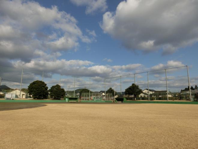 フェンスを挟んで戸建て住宅が並んでいる場所にあり、広々としたグラウンドが広がっている南九州市知覧平和公園多目的球場の写真