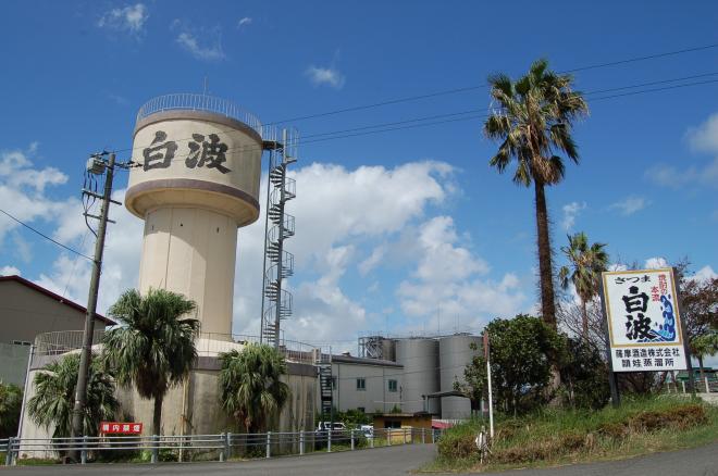 入口に縦看板があり、「白波」と書かれた建物に螺旋階段が設置されている薩摩酒造株式会社 頴娃蒸留所の写真