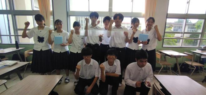 教室の中で11人の川辺高校の生徒が片手で拳を作ってポーズをとっている写真