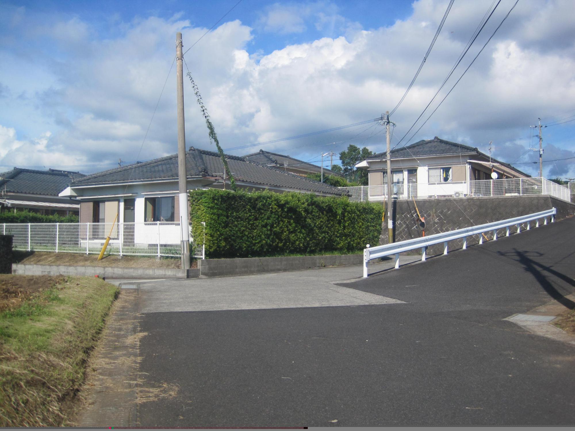 白いフェンスと垣根の奥に建っている1階建て住宅の市営住宅 特公賃三俣団地の写真