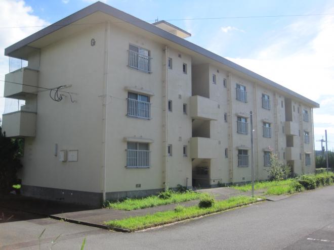 外壁が薄いベージュ色で窓に柵が設置されている3階建ての市営住宅 公営水垂団地G棟の写真