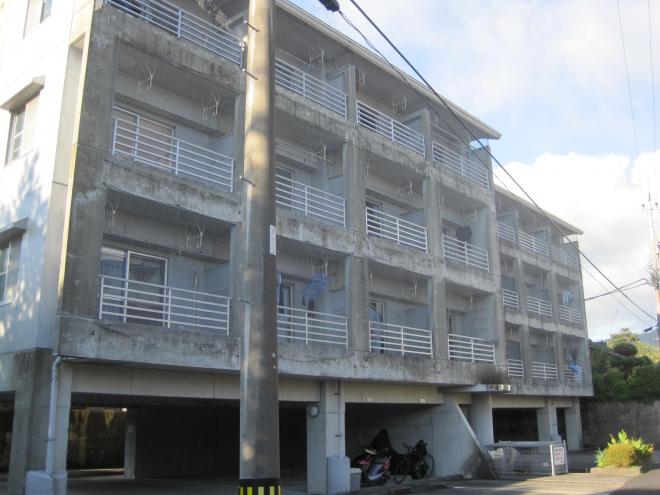 1階部分がバイクや自転車の駐車スペース、2階から4階部分が居住スペースになっている、ベランダ側が写っている市営住宅 一般平屋敷団地の写真