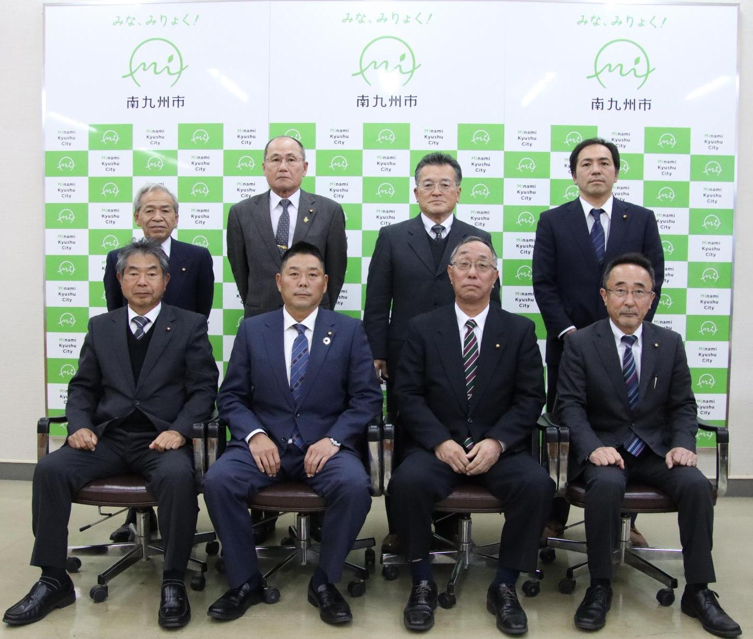 議会運営委員会の8名が2列に並び、前列は椅子に座り、後列は椅子の間に立って写っている集合写真