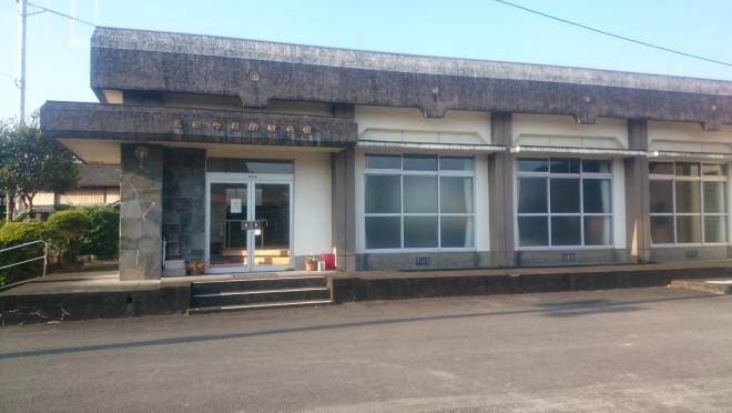 大きな窓ガラスが多用された、コンクリート製の陸屋根でできており、玄関ポーチに高田多目的研修館と書かれた平屋建ての高田多目的研修館外観写真