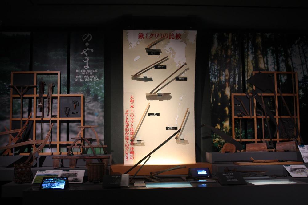 博物館の展示室で，鹿児島県や沖縄県の鍬の特徴が比較されている。