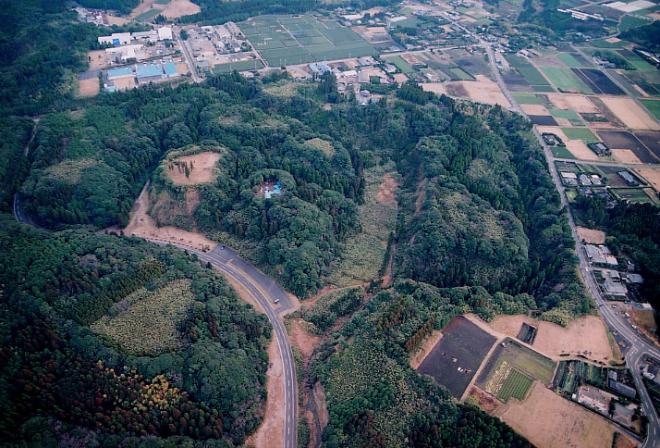 たくさんの木々などの自然に囲まれ、周囲には田畑が広がっている知覧城跡を上空から撮影した写真