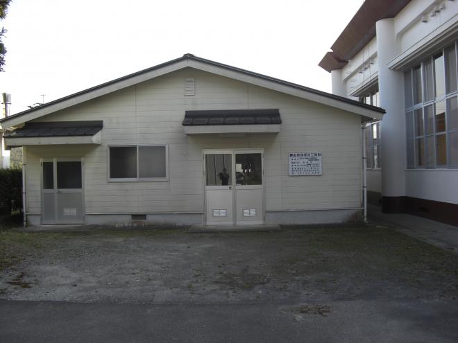 三角屋根で白壁の建物であり、二か所の出入口の上部には雨よけが設置されている南九州市知覧農産物処理加工施設の外観写真