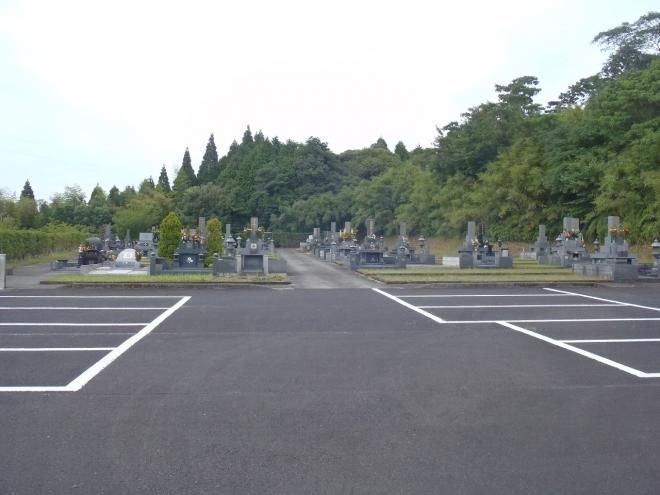 木々に囲まれた墓地の前に、駐車場が設置された知覧墓地公園の写真