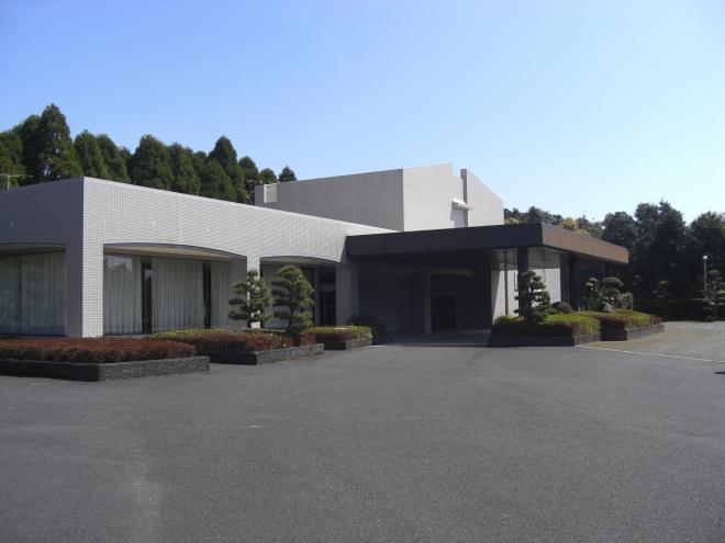 四角いグレーの外観であり周りには数本の植木が植えられた南九州市頴娃浄楽苑の写真