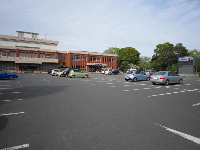赤茶色を基調とした2階建ての建物で、手前に駐車場がたくさんあるコミュニティセンター知覧文化会館の写真
