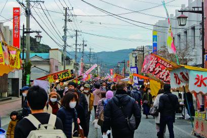 歩行者天国になった道路の両側にたくさんの出店が出ており、多くの見物客でにぎわっている様子の写真