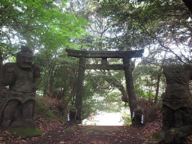 木々の中に石の鳥居があり、手前の両側に石造の仁王像・狛犬が立っている大野嶽神社の写真