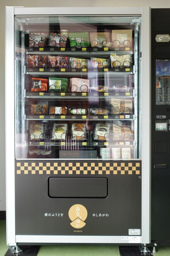 お茶の葉やお菓子が陳列された常温自販の写真